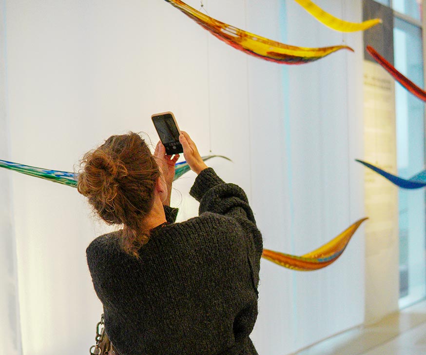 Kvinde tager billeder af en af de smukke udstillinger på Glasmuseet i Ebeltoft